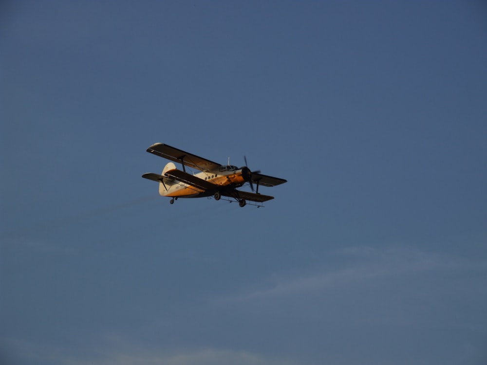 white and black plane flying in the sky during daytime