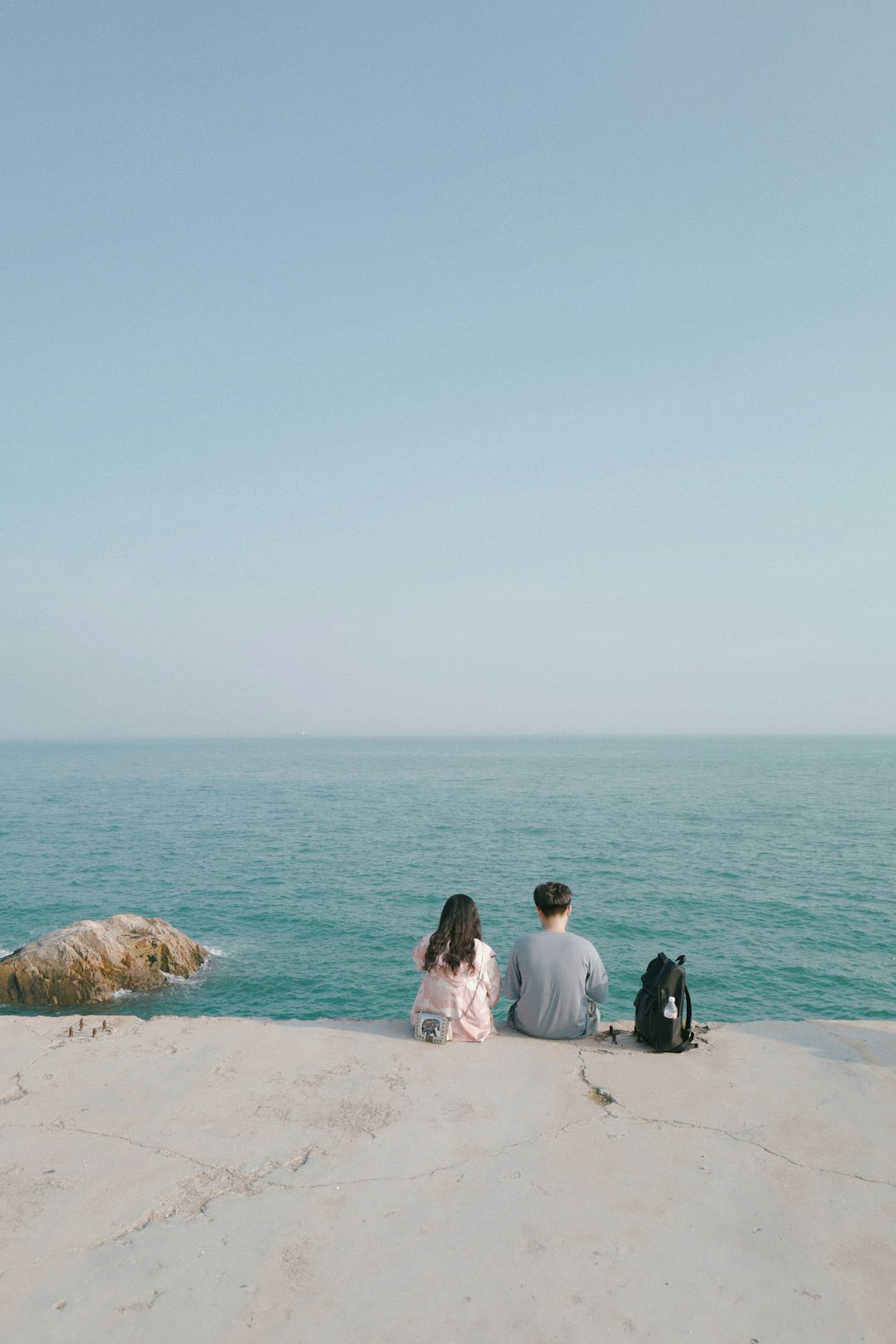 man and woman sitting on beach during daytime