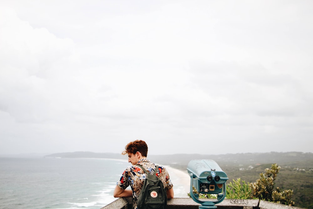 man in black and white floral shirt sitting on blue and black motorcycle looking at the on on on on