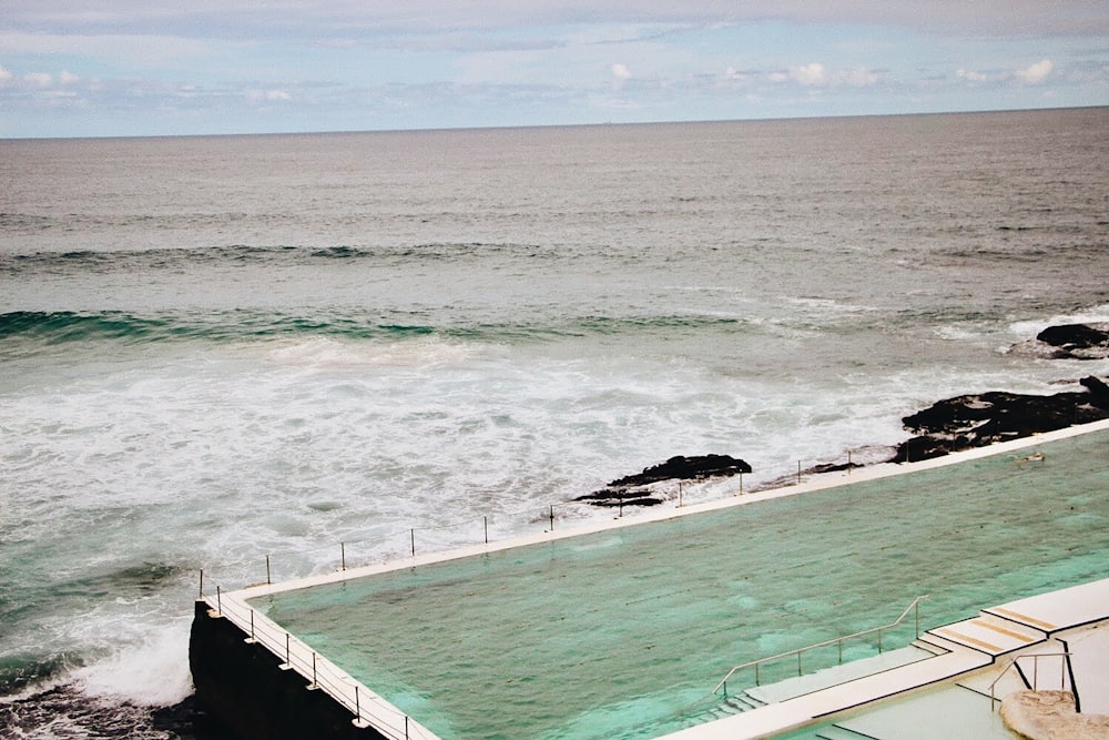 昼間の海上の白い木造のドック