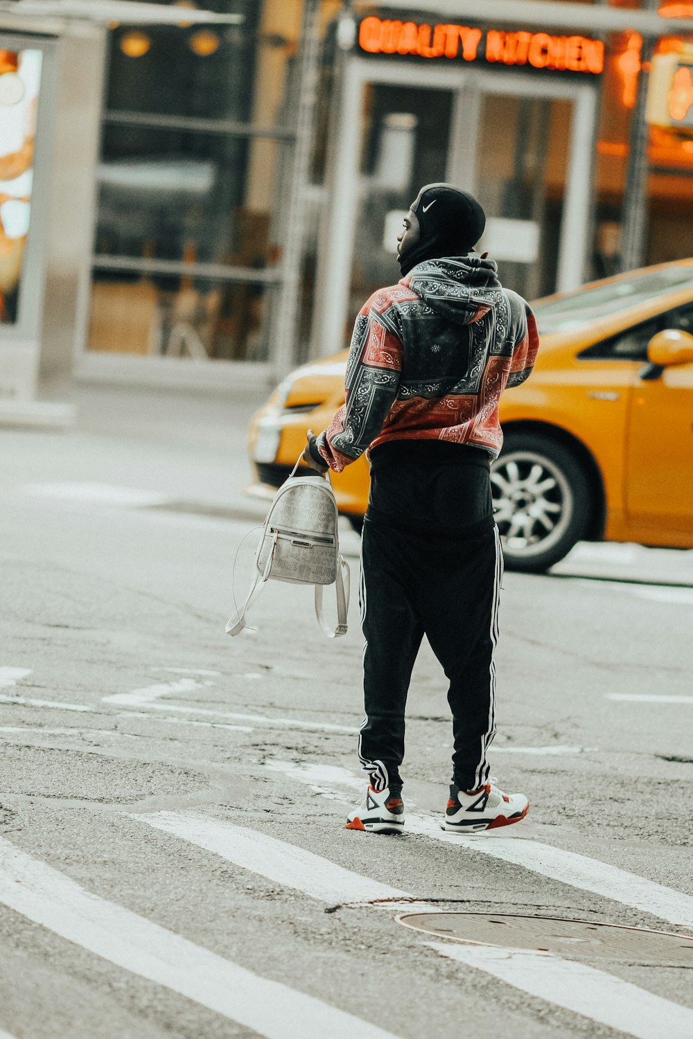 Foto de hombre con chaqueta negra y pantalones negros con zapatillas nike  blancas parado en la carretera durante el día – Imagen gratuita en Unsplash