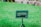 A green lawn with a sign that reads 'Lawn Closed. The new sod is establishing its roots.' The sign is positioned in the forefront on a metal stand, surrounded by vibrant green grass.