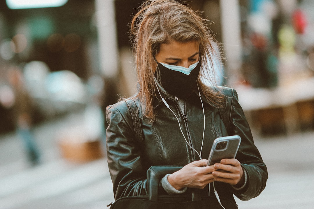 woman in black leather jacket holding smartphone