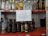 A shelf with various brands of alcoholic beverages, including bottles of vodka, rum, tequila, and whiskey. In the center, a handwritten sign reads 'LEY SECA' indicating a dry law or prohibition.