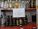 A shelf with various brands of alcoholic beverages, including bottles of vodka, rum, tequila, and whiskey. In the center, a handwritten sign reads 'LEY SECA' indicating a dry law or prohibition.