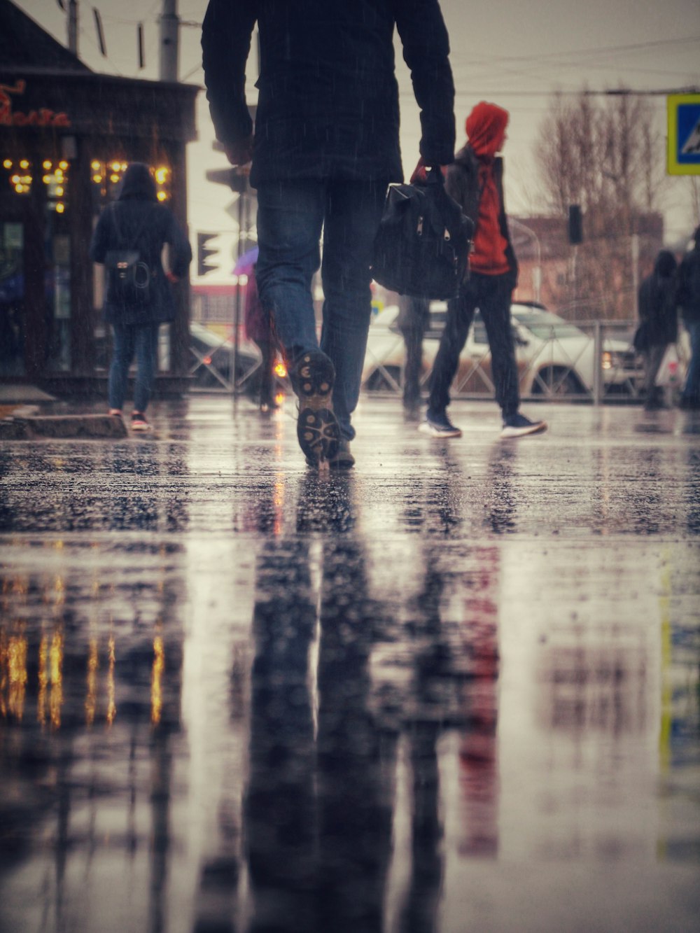 people walking on wet road during night time