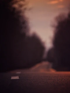 A split road disappearing into a horizon where light and darkness meet in a celestial clash.
