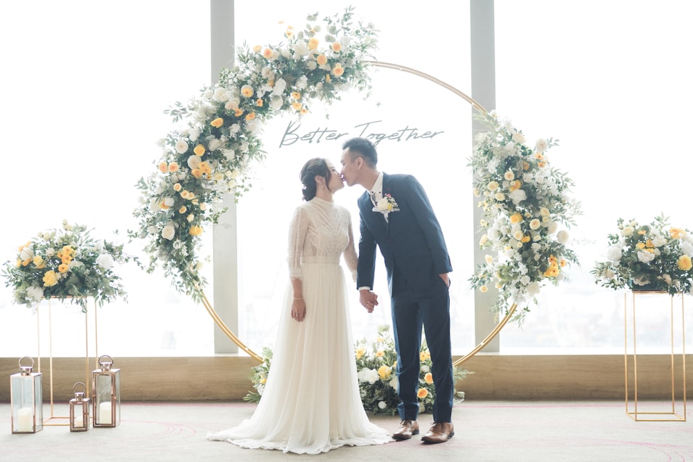 man in black suit standing beside woman in white wedding dress