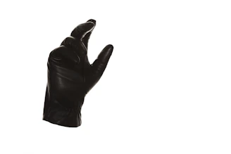 Close-up of elegant black gloves resting on finely crafted restraints.