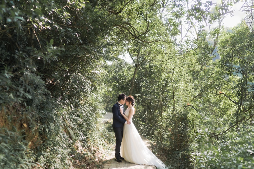 bride and groom kissing on the woods during daytime