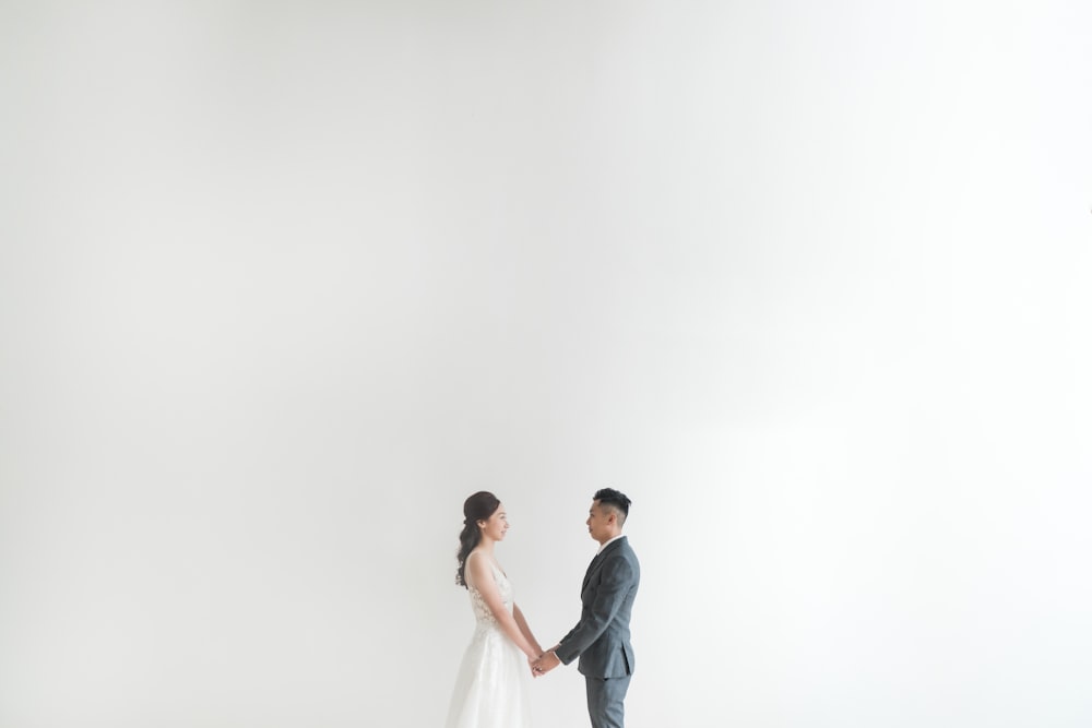 man in black suit kissing woman in white wedding dress