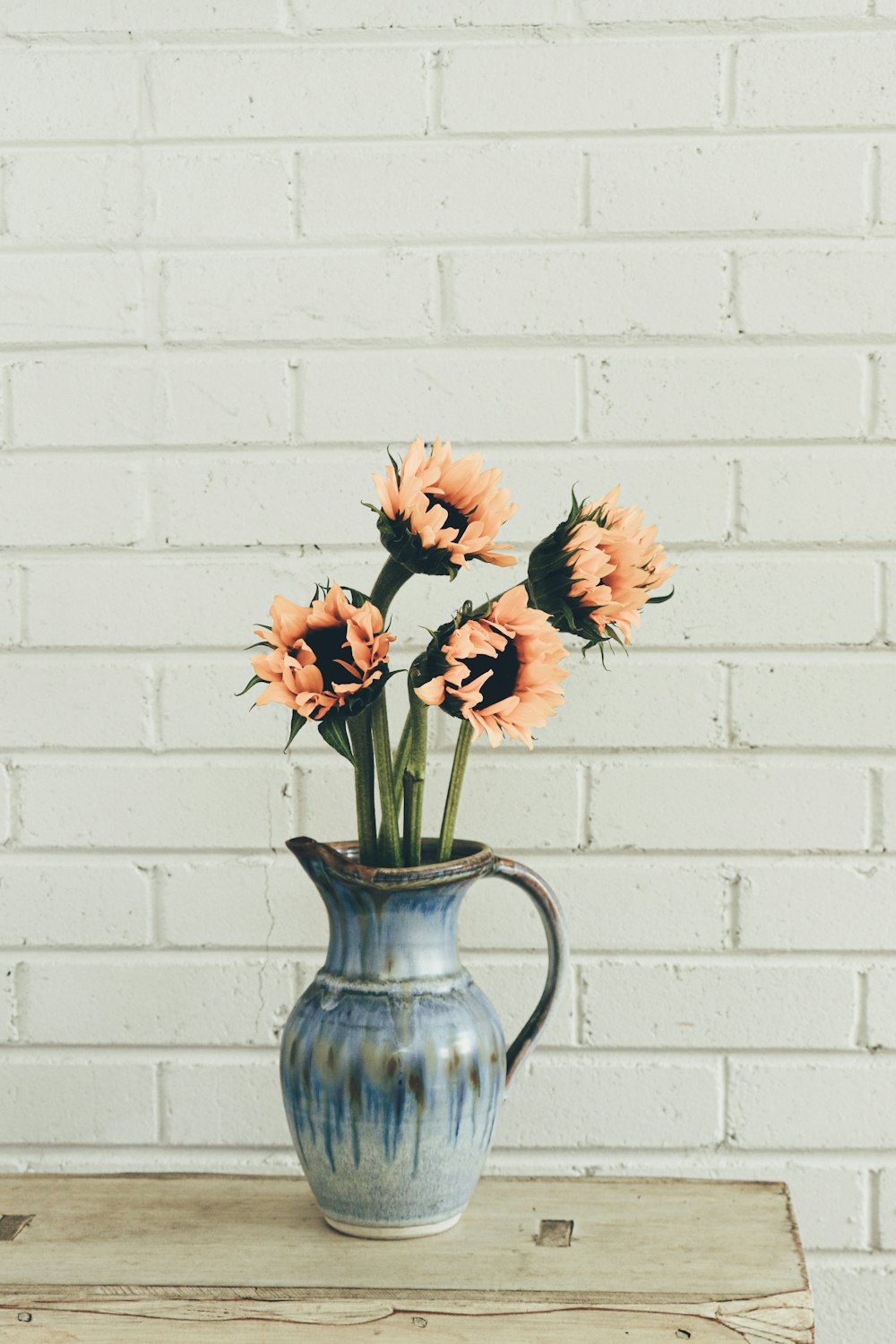 orange flowers in blue ceramic vase