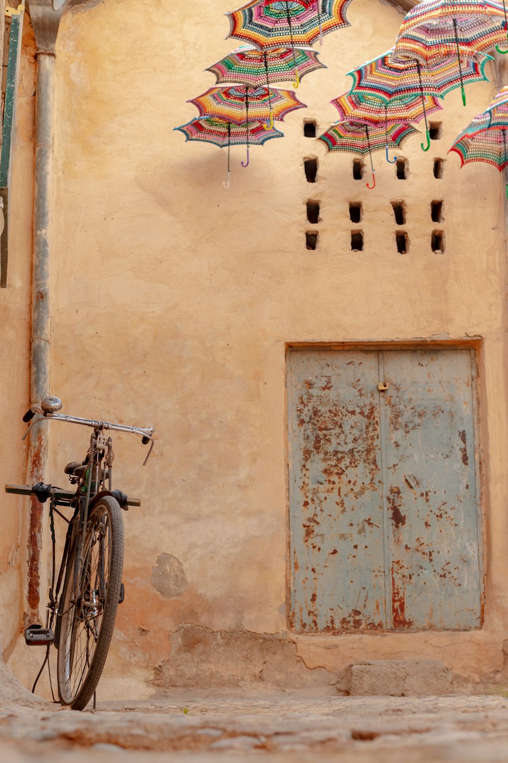 bicicletta nera appoggiata al muro di cemento marrone