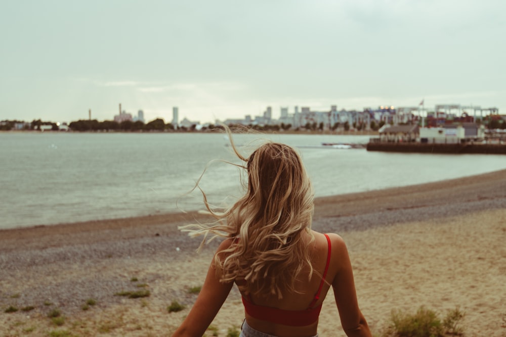 woman in red bikini standing on beach during daytime