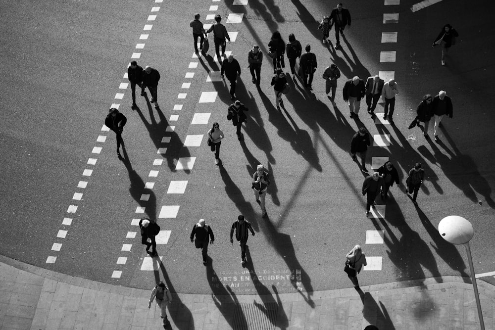 people walking on pedestrian lane in grayscale photography