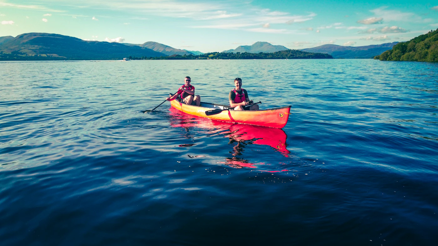 Deux personnes pagayant sur un lac bleu