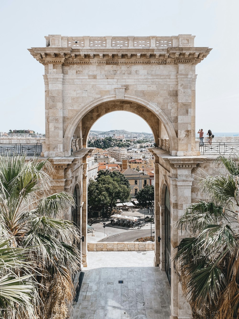 Persone che camminano sull'arco di cemento grigio durante il giorno