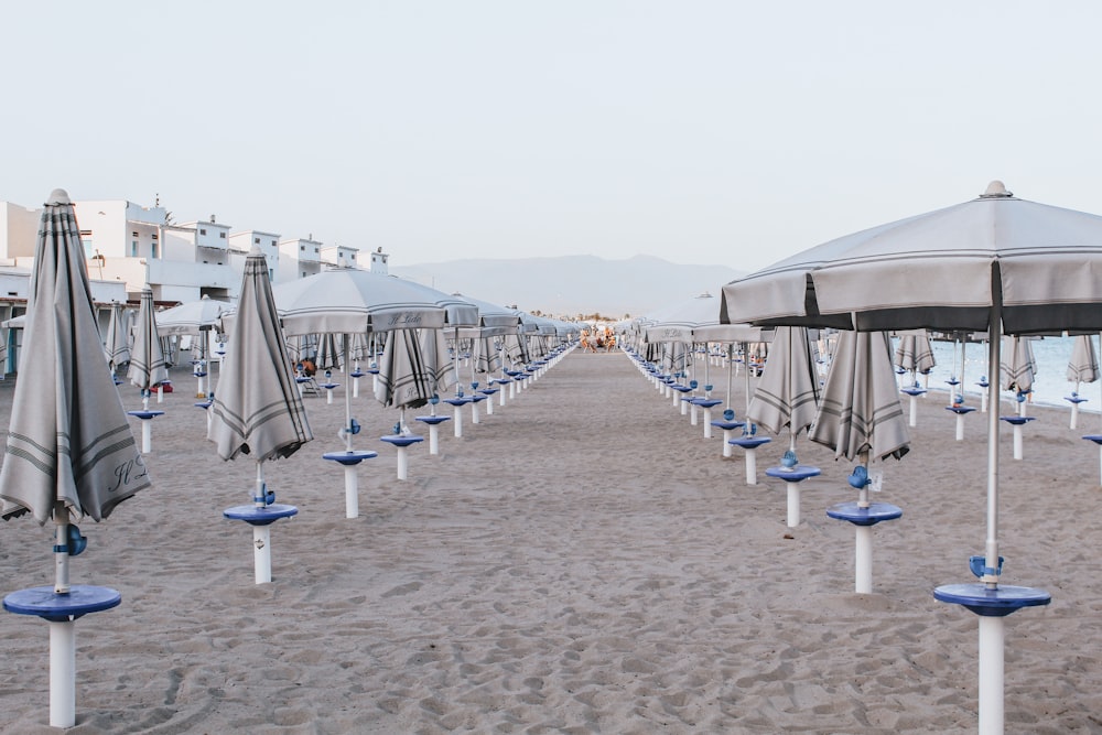 white and blue beach umbrellas on beach during daytime