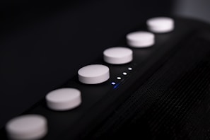 A close-up of a high-tech device with illuminated buttons against a dark background