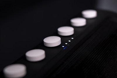 Close-up of a sleek electronic device with illuminated buttons.