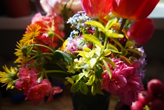 A vibrant bouquet featuring a mix of roses, tulips, and daisies basking in soft natural light.