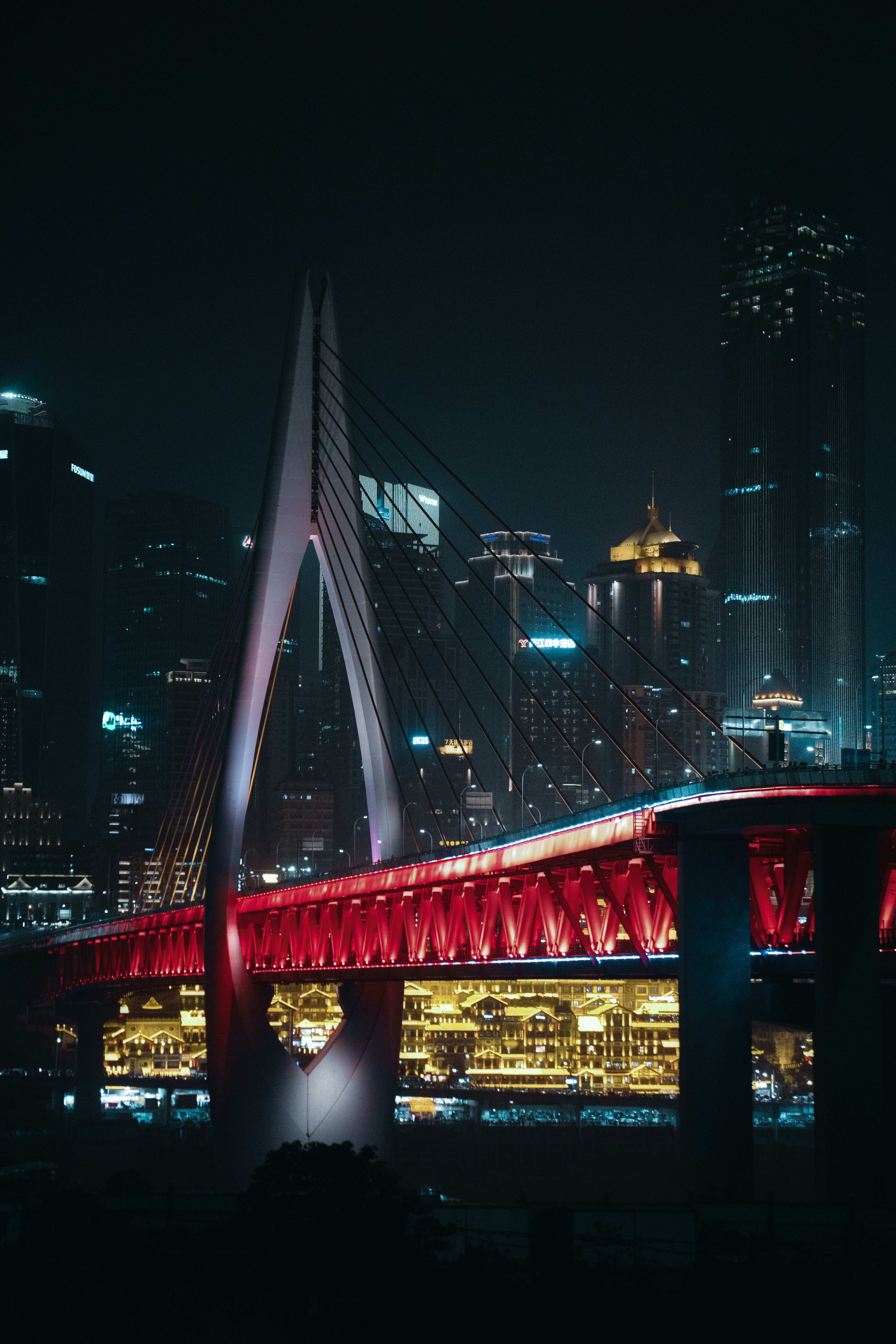 red bridge over body of water during night time