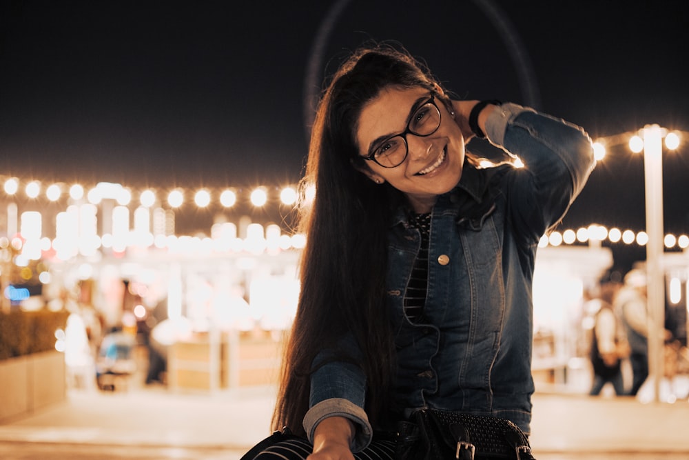 woman in blue denim jacket wearing black framed eyeglasses