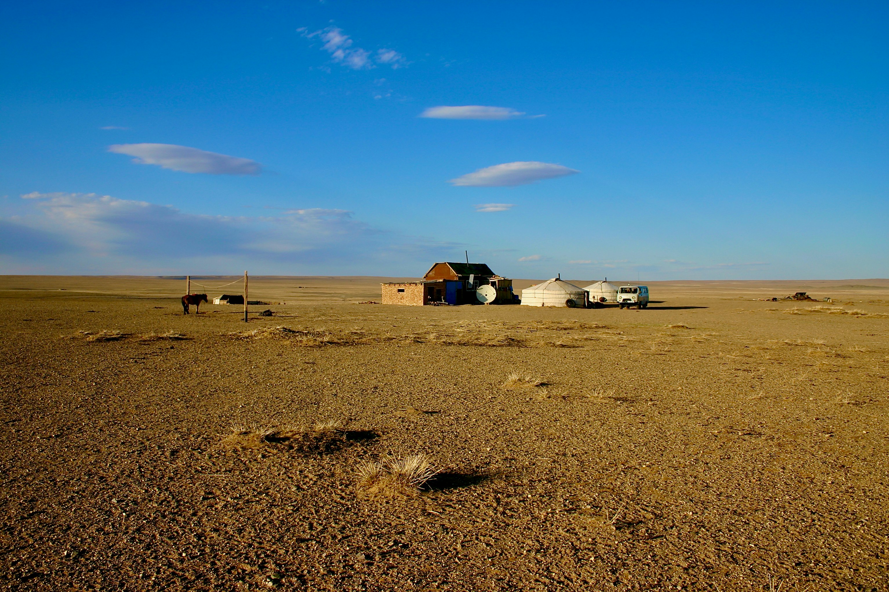 white and brown house on brown sand under blue sky during daytime