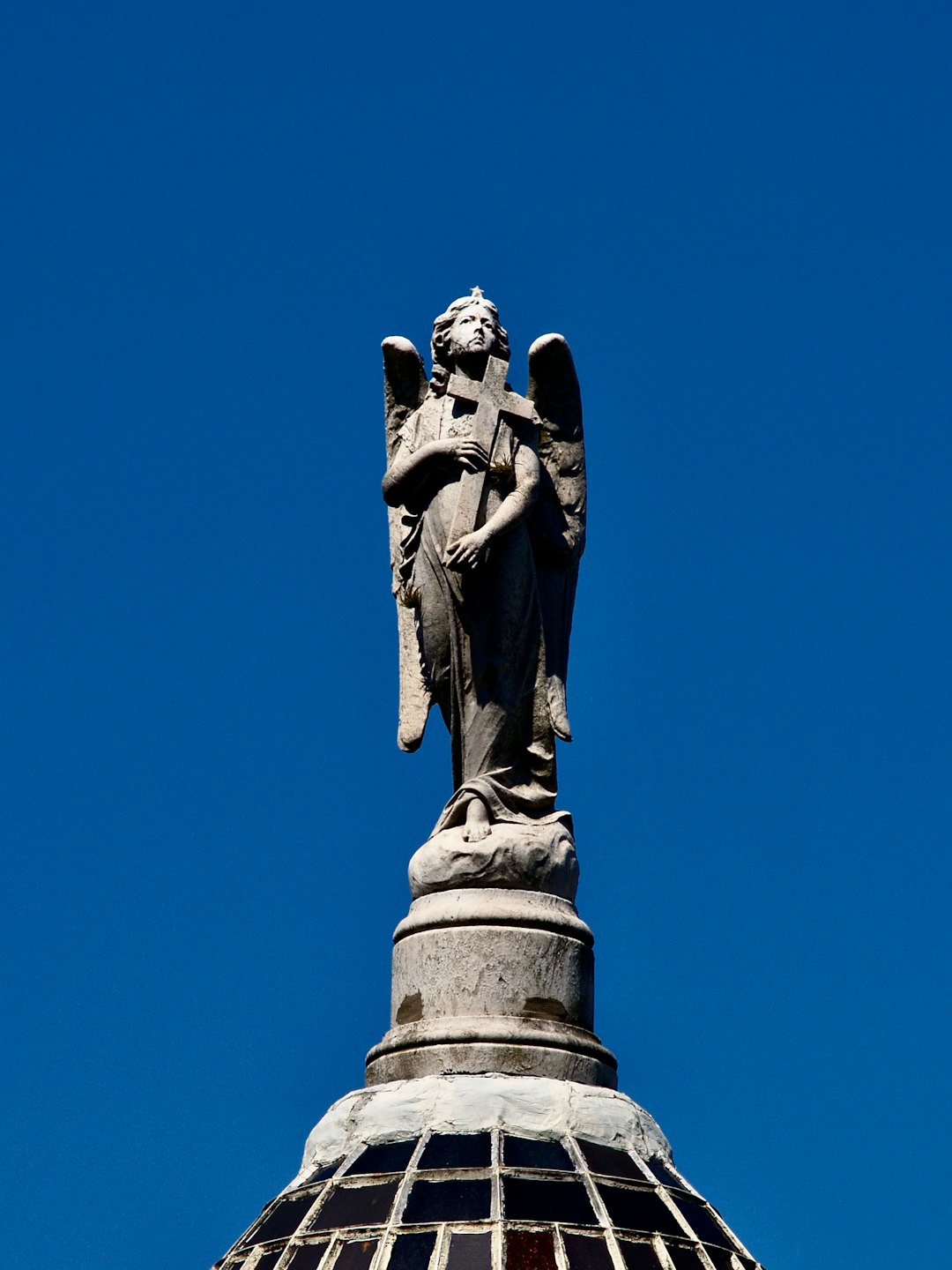 man holding book statue under blue sky during daytime