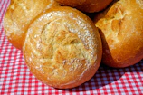 Artisan bread rolls with a crisp crust resting on a cream linen cloth.