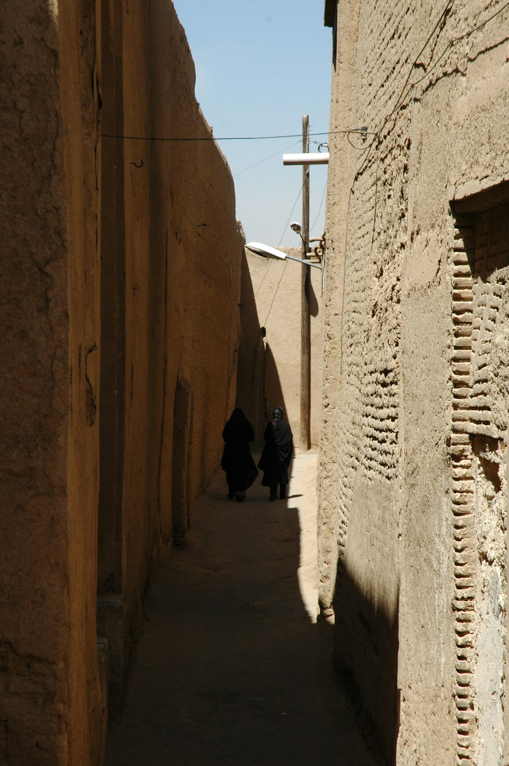 person in black coat walking on hallway