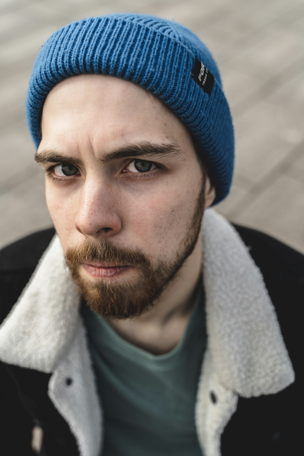 man in blue knit cap and green crew neck shirt