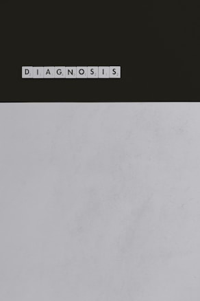 A series of Scrabble tiles spelling out the word 'DIAGNOSIS' is arranged horizontally on a surface. The background is divided, with a dark upper section and a light lower section.