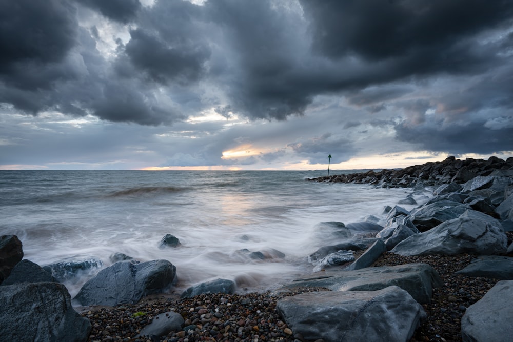 rocky shore under cloudy sky during daytime