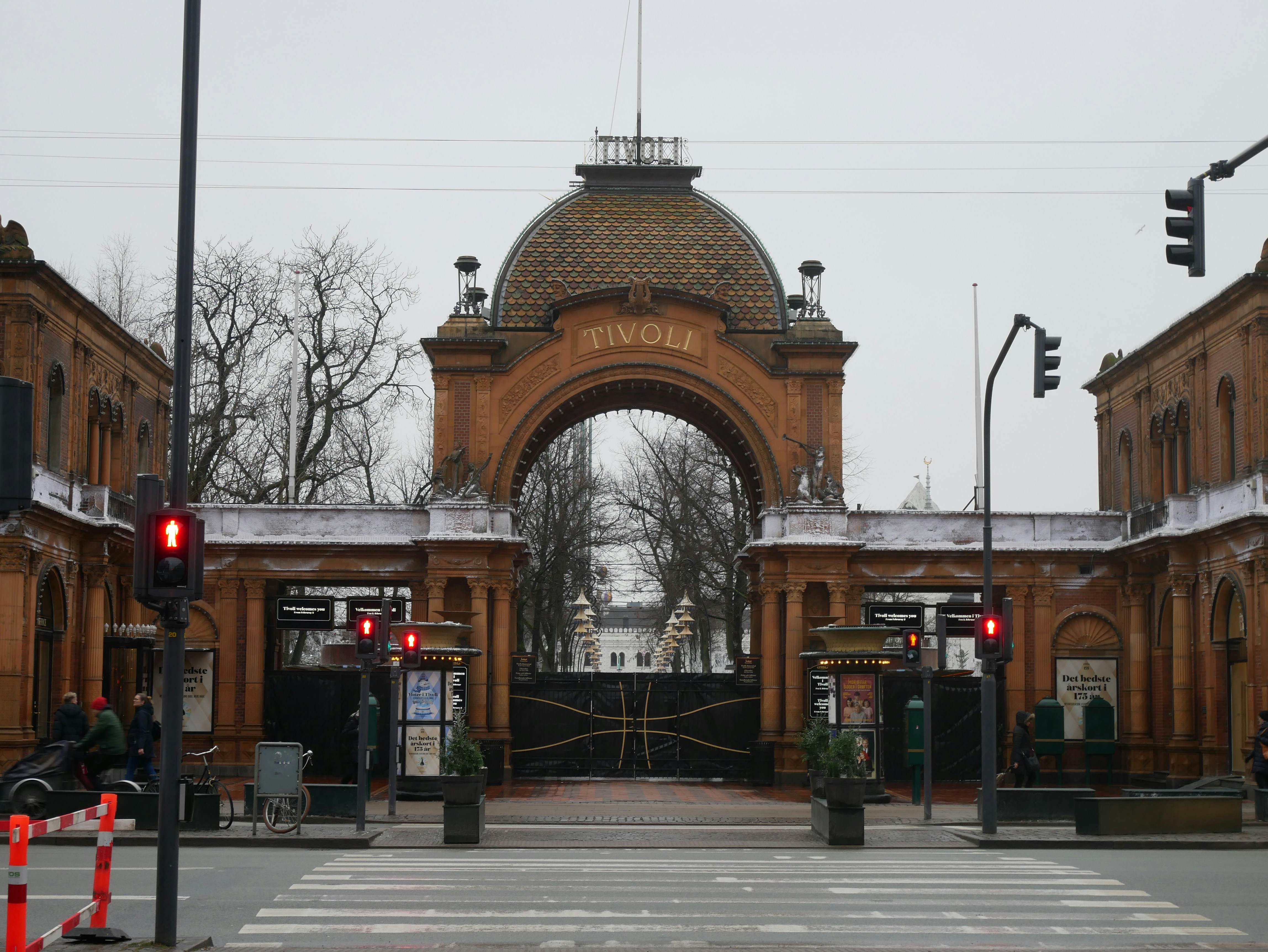 brown concrete building near bare trees during daytime, Entrance arch and gate to Tivoli Gardens in Copenhagen