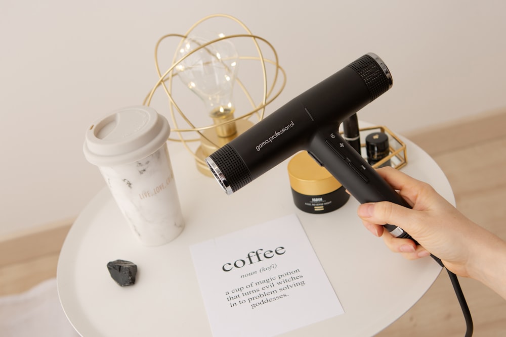 black and white plastic cup beside black and white plastic bottle