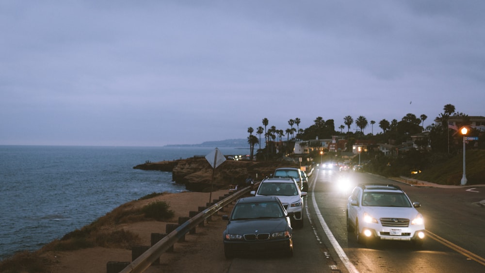 cars on road near body of water during daytime