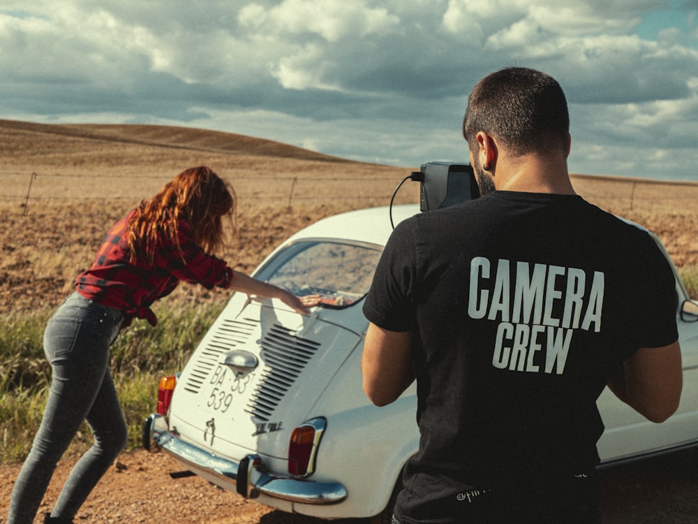 man in black crew neck t-shirt standing beside woman in red jacket