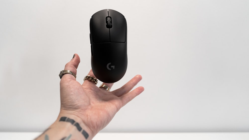 person holding black hp cordless computer mouse