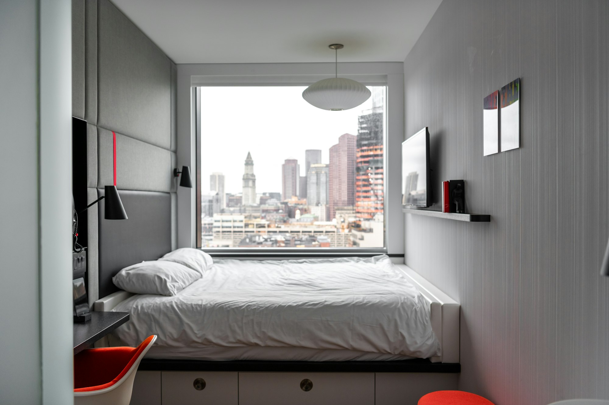 A bedside window of a condominium with skyline view.