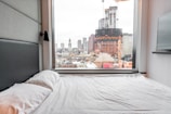 A spacious bedroom with a stunning city view and stylish decor.