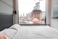A luxurious master bedroom with a city view.