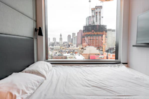 Master bedroom featuring a king-size bed and panoramic city views at dusk