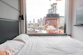 Sunlit bedroom with modern furnishings and city views.