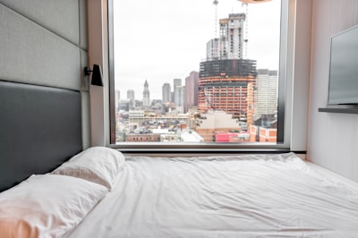 Sunlit bedroom with modern furnishings and city views.