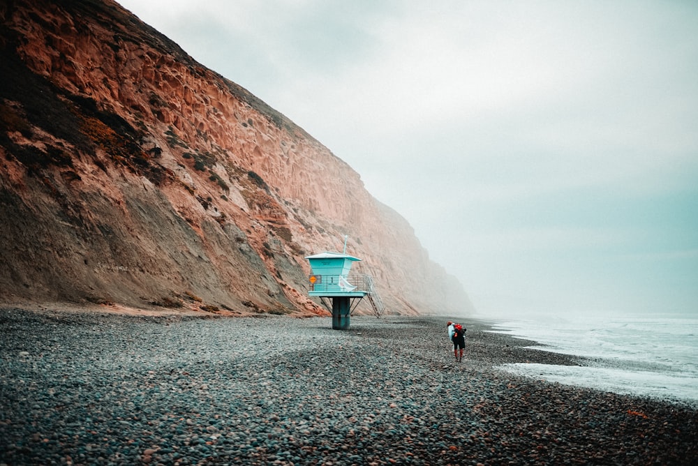 person in white shirt walking on beach during daytime