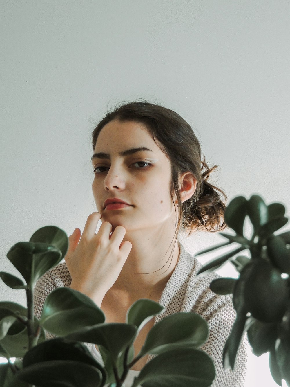 woman in white and black striped shirt holding green plant