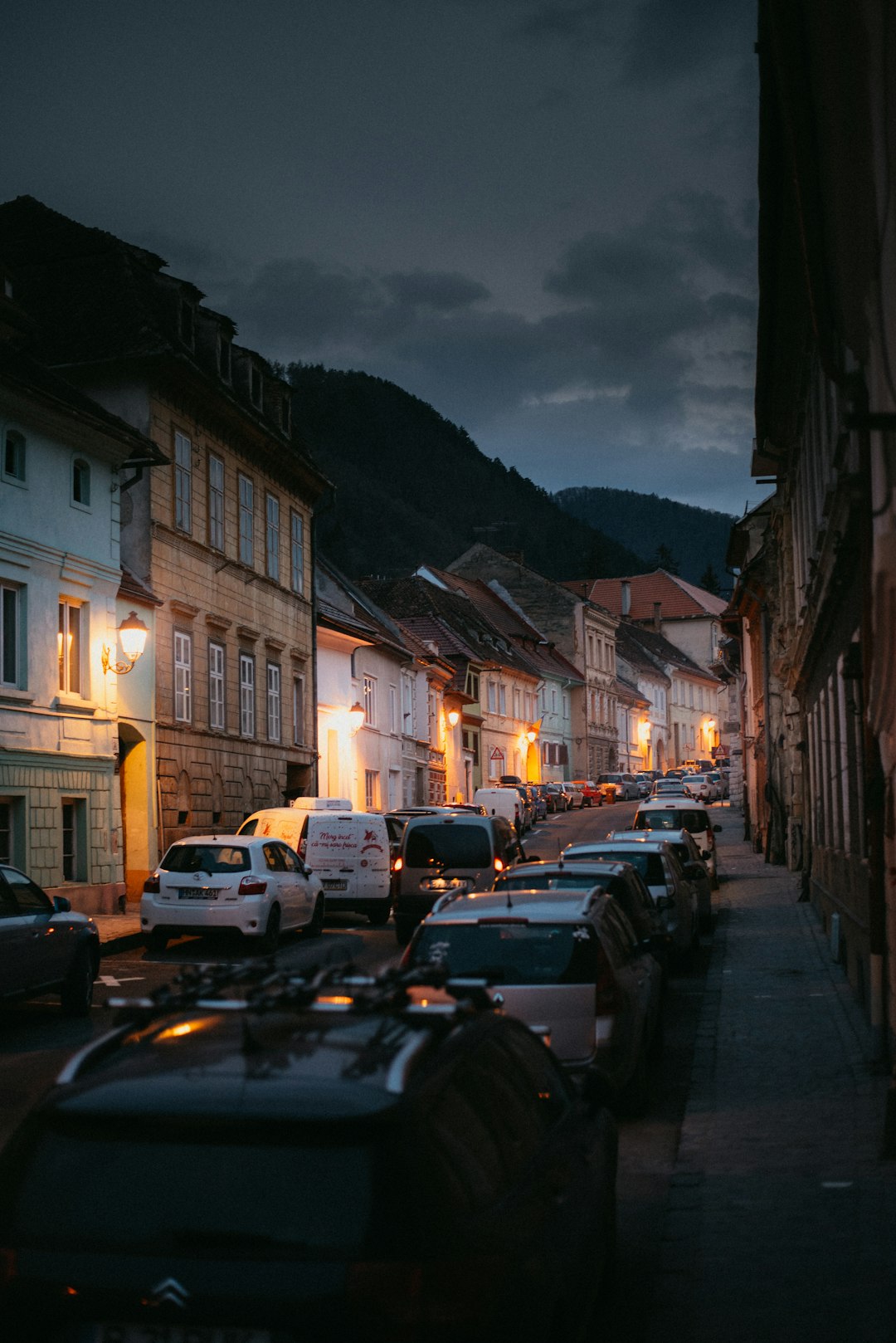 cars parked on side of road near buildings during night time