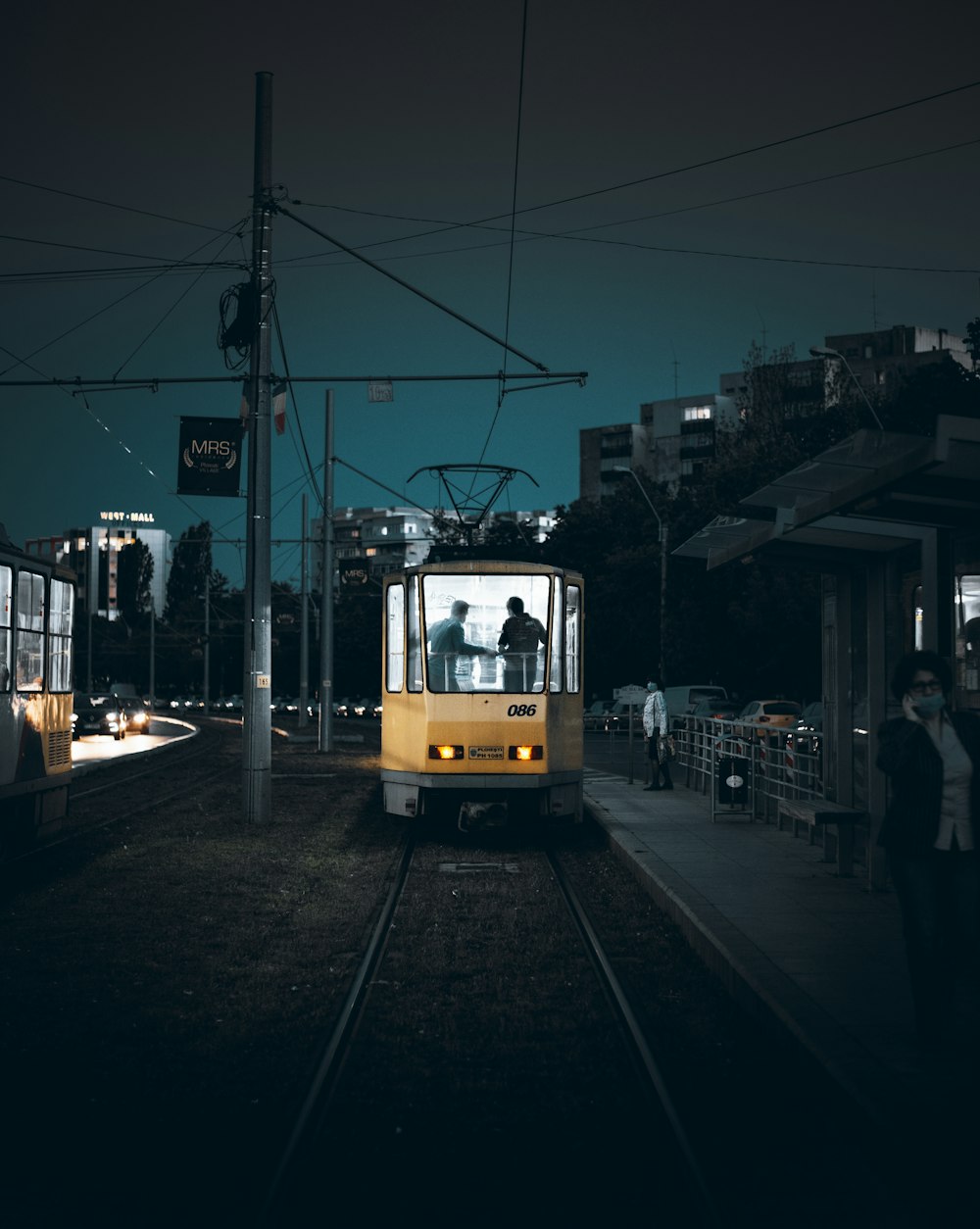 yellow and white tram on road during night time