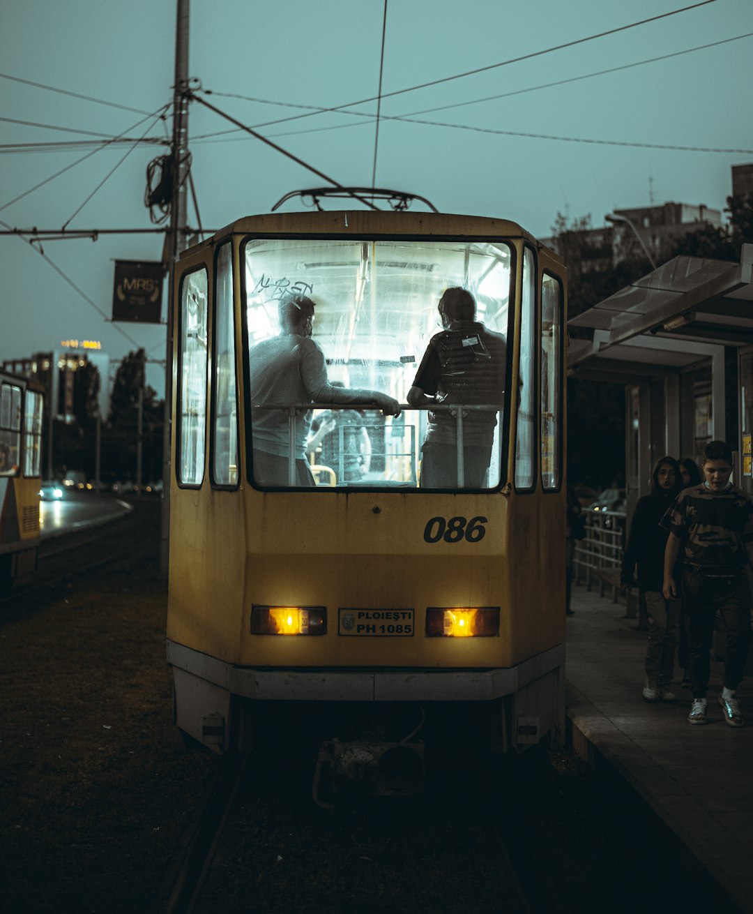 man in white shirt riding yellow and white tram